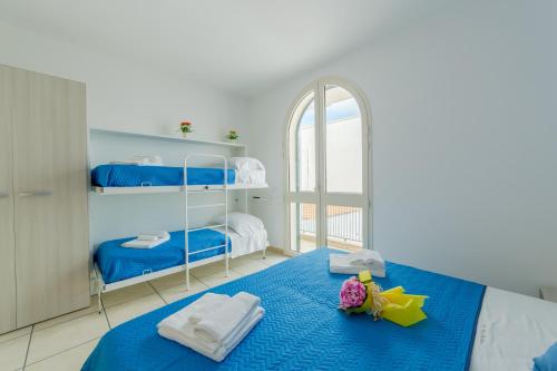 a bedroom with two bunk beds and a blue blanket at Casa Vacanze Dei Bacini in Porto Cesareo
