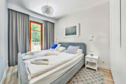 een slaapkamer met 2 bedden en een raam bij Apartamenty Sun & Snow Królewskie Kamieniczki in Sopot