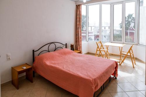 a bedroom with a bed and a table and a window at Madalenas B&B in Pelekas