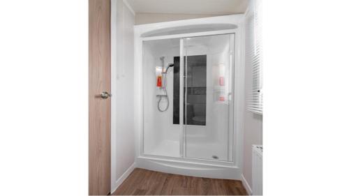 a bathroom with a glass shower in a room at Caravan on Fantastic site in Dunbar