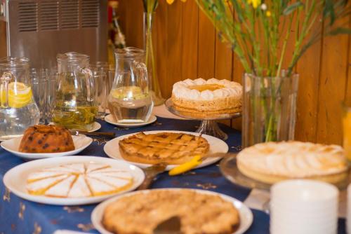 a table topped with pies and cookies on plates at Hotel Terrazas del Lago in Puerto Varas