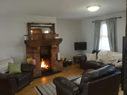 a living room with a fireplace and couches at Spindrift in Moville