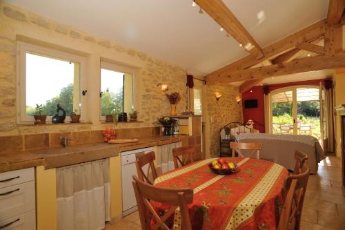 a kitchen with a table with a bowl of fruit on it at Gîtes Domaine des Machottes in Grans