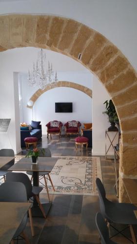 a living room with an archway with chairs and tables at Viacolvento in Marsala