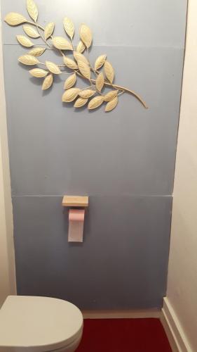 La salle de bains est pourvue de toilettes avec une fleur sur le mur. dans l'établissement Les Tomettes, à Dole