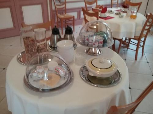 einem weißen Tisch mit Tellern und Geschirr darauf in der Unterkunft Château des marronniers in Baizieux