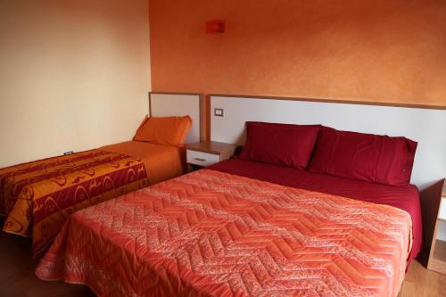 een slaapkamer met 2 bedden en rode lakens bij B&B DEL CORSO in Gangi
