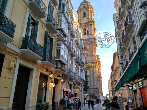 una calle de la ciudad con una torre de reloj a la distancia en Casa Blanca, en Málaga