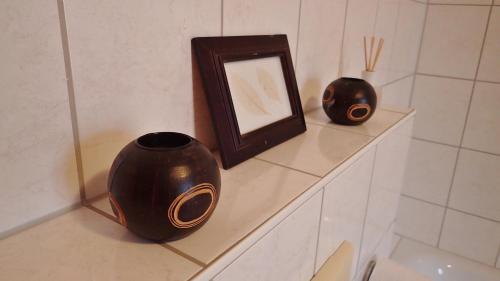 two vases sitting on a shelf with a mirror at 3 Raum Ferienwohnung in Jena