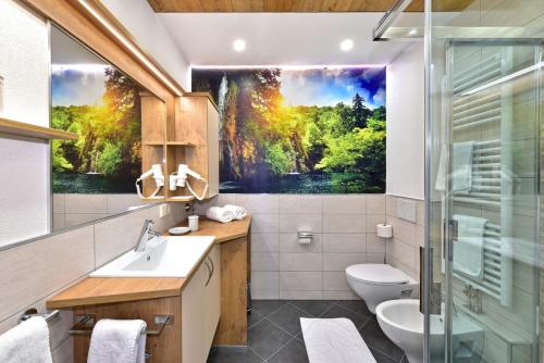 a bathroom with a painting on the wall at Residence Treyer in Terento
