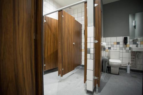 a bathroom with a toilet and a wooden door at PubLove @ The Crown, Battersea in London