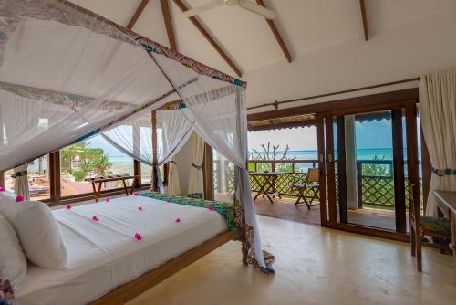1 dormitorio con 1 cama y vistas al océano en Warere Beach, en Nungwi