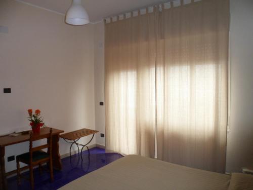 a bedroom with a bed and a desk and a table at Hotel Panorama di Sicilia in Castelmola