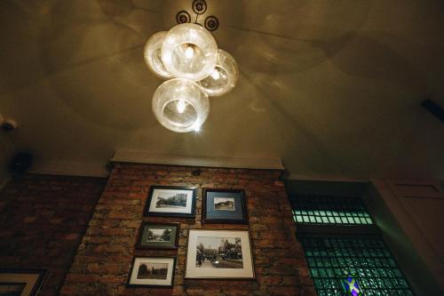a chandelier and framed photos on a brick wall at PubLove @ The Crown, Battersea in London