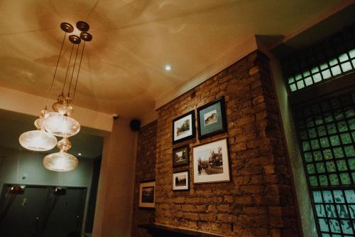 a room with a brick wall and a chandelier at PubLove @ The Crown, Battersea in London