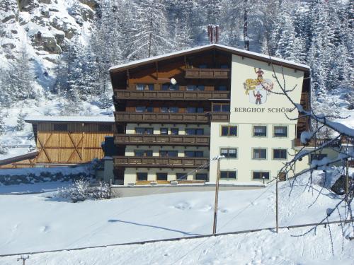 ein Gebäude im Schnee mit einem Schild drauf in der Unterkunft Gästehaus Berghof Schöpf in Längenfeld