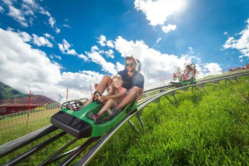 a man and a little girl riding on a roller coaster at Apartment Kaprun in Niedernsill
