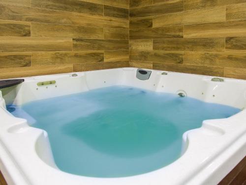 a bath tub filled with blue water in a room at DWIE SOSNY Apartament 52 in Ustronie Morskie