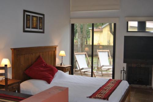 a bedroom with a bed and a television and a balcony at Cabañas el Ensueño in Santa Ana