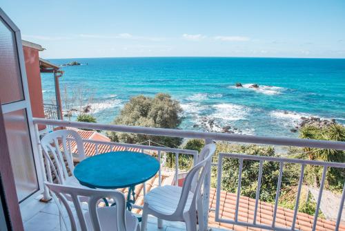a balcony with a table and chairs and the ocean at Madalenas B&B in Pelekas