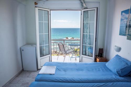 a bedroom with a bed and a view of the ocean at Madalenas B&B in Pelekas