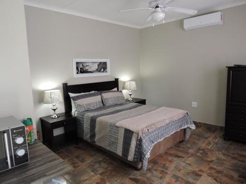 a bedroom with a bed and a ceiling fan at Hluhluwe Country cottages in Hluhluwe