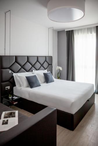 a bedroom with a large bed with a large headboard at Miramare The Palace Resort in Sanremo