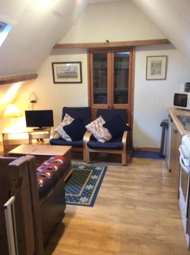 a living room with a couch and a table at Ranvilles Farm House in Romsey