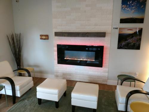 a waiting room with a fireplace and white chairs at Lewis River Inn in Woodland