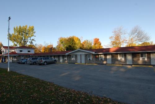 a building with cars parked in a parking lot at Kings Inn Orillia in Orillia