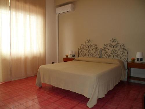 sypialnia z łóżkiem w pokoju z oknem w obiekcie Hotel Panorama di Sicilia w mieście Castelmola