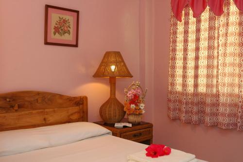 a bedroom with a bed and a lamp on a night stand at Masamayor's Beach House and Resort in Camotes Islands