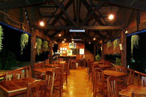 une salle à manger avec des tables et des chaises en bois dans l'établissement Masamayor's Beach House and Resort, à Îles Camotes
