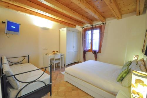 um quarto com uma cama, uma secretária e uma janela em Agriturismo Monte degli Aromi em Villaga