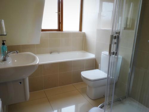 a bathroom with a sink and a toilet and a shower at Kilchoan Hotel in Kilchoan