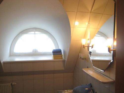 a bathroom with a window and a sink and a mirror at Ferienhaus Uhlenhorst in Büsumer Deichhausen