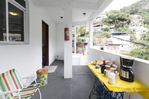 einen Balkon mit einem gelben Tisch mit Essen drauf in der Unterkunft Natural Do Rio Guesthouse in Rio de Janeiro