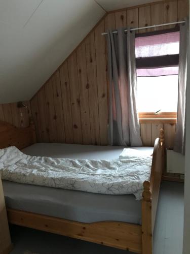 a bed in a room with a window at Kjelkebakken Gard in Lyngseidet