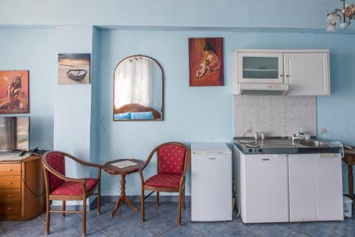 a kitchen with two chairs and a table and a sink at Madalenas B&B in Pelekas