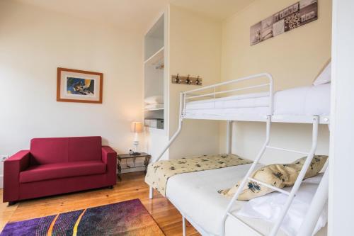 ポルトにあるÀ Francos Burguer Stationのベッドルーム1室(二段ベッド1組、赤い椅子付)