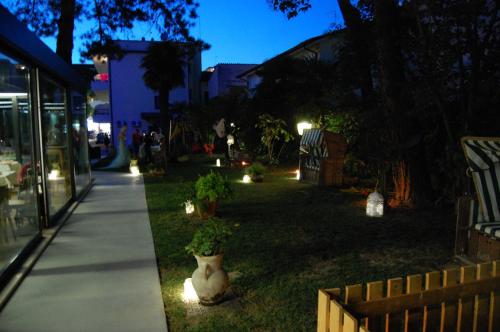 a garden with lights in the grass at night at Hotel Adria in Lignano Sabbiadoro