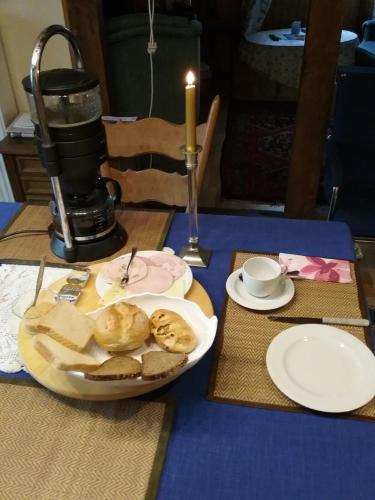 a table with a plate of bread and a candle at Refugium Thanatcha in Reil