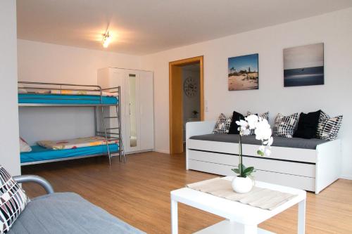 ein Wohnzimmer mit 2 Etagenbetten und einem Tisch in der Unterkunft Ferienwohnung Hegau-Bodensee in Mühlhausen-Ehingen
