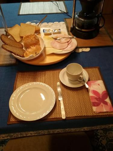 a table with a plate of food and a plate of bread at Refugium Thanatcha in Reil