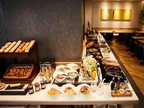 a buffet line with plates of food in a restaurant at Hotel Intergate Tokyo Kyobashi in Tokyo