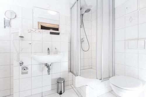 a bathroom with a shower and a toilet and a sink at Hotel Haus im Sack in Jena
