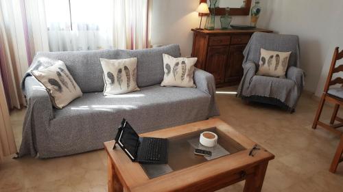 sala de estar con sofá y mesa de centro con ordenador portátil en 755 Las Ramblas Golf, en Villacosta