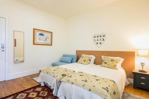 a bedroom with a large bed and a blue chair at À Francos Artist Painting in Porto