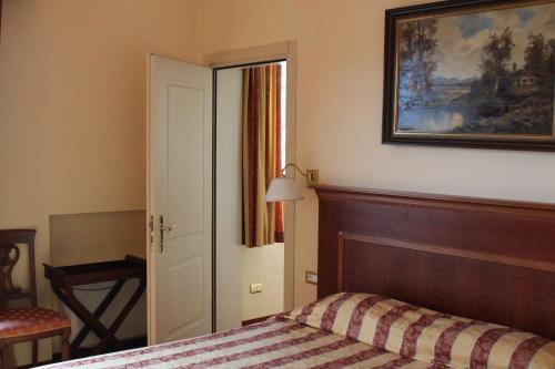 a bedroom with a bed and a picture on the wall at Hotel La Dolce Vita in Cavaion Veronese
