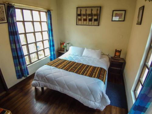a bedroom with a bed and a large window at Casa del Arupo in Quito